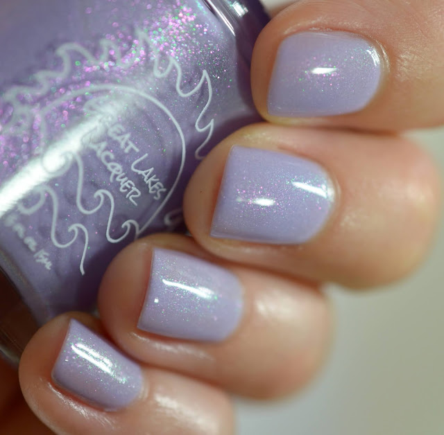 pastel lilac nail polish with green and pink shimmer shown on white person's hands
