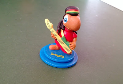 Miniatura de vinil estática sobre base redonda giratória do tortuguita jamaicano com guitarra - promocional dos chocolates Arcor  5cm de  altura - R$ 10,00