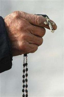 A faithful holds the cross during a mass at a Catholic church on the outskirts of Changzhi, Shanxi province December 23, 2007. The Vatican has told the faithful that they should be aware of 'new' sins such as causing environmental blight. REUTERS/Stringer