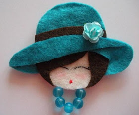 rosto de daminha em feltro com chapéu e flor