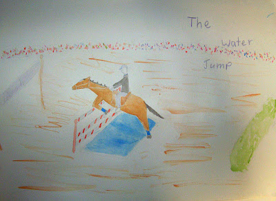 horse and rider taking the water jump, where the horse must first leap over a small pool of water before clearing the jump.