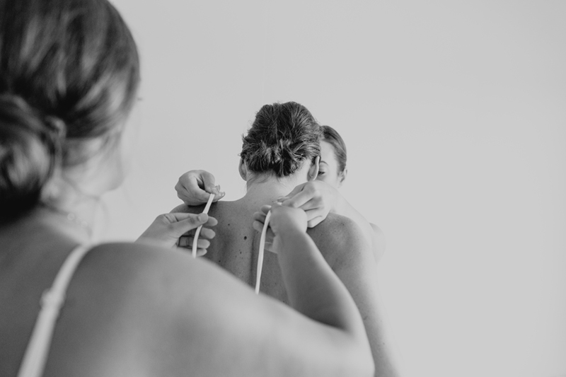 bw shot of bride getting dressed