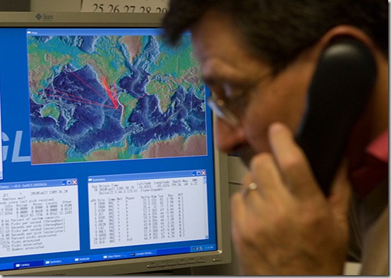 With a computer graphic showing the possible path of tsunami waves from an earthquake in Chile, Dr. Charles McCreery speaks on the phone at the Pacific Tsunami Warning Center, Saturday, Feb. 27, 2010 in Ewa Beach, Hawaii.  The State of Hawaii is under a tsunami warning after an 8.8 magnitude earthquake rattled Chile today.  (AP Photo/Marco Garcia)