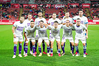 REAL VALLADOLID C. F. Temporada 2021-22. Óscar Plano, Joaquín, Kiko Olivas, Javi Sánchez, Roberto. Shon Weissman, Anuar, Luis Pérez, Álvaro Aguado, Nacho y Roque Mesa. Los jugadores del Valladolid se fotografiaron con camisetas de apoyo a Hugo Vallejo, lesionado de gravedad durante la semana. GIRONA F. C. 1 REAL VALLADOLID C. F. 0. 18/09/2021. Campeonato de Liga de 2ª División, jornada 6. Girona, estadio Municipal de Montilivi. GOLES: 1-0: 60’, Stuani, de penalti.