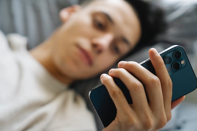 A guy resting checking a modern handphone