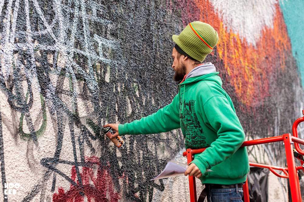 Street Artist Lousi Masai at work on a mural in Walthamstow, London