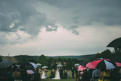 Guests holding umbrellas during the ceremony