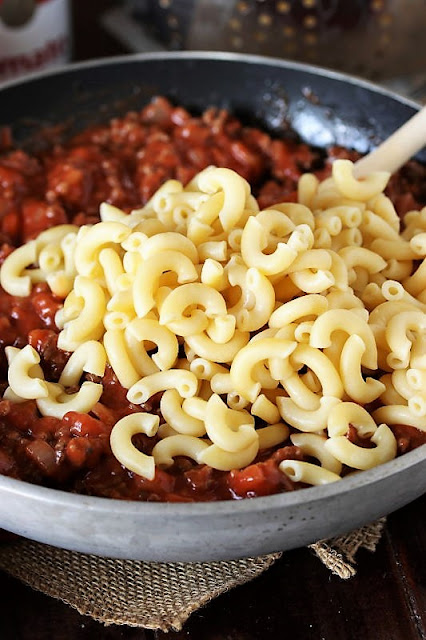 Adding Cooked Macaroni Noodles to Sauce to Make Goulash Image