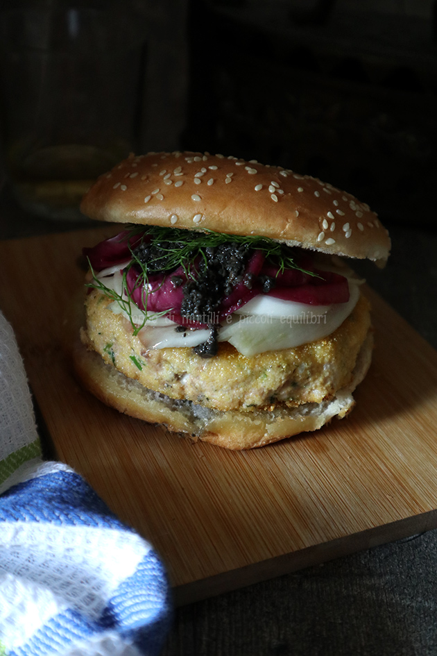 Panino con burger di salmone, finocchi sott’aceto, cipolle rosse sott'aceto e salsa tartufata