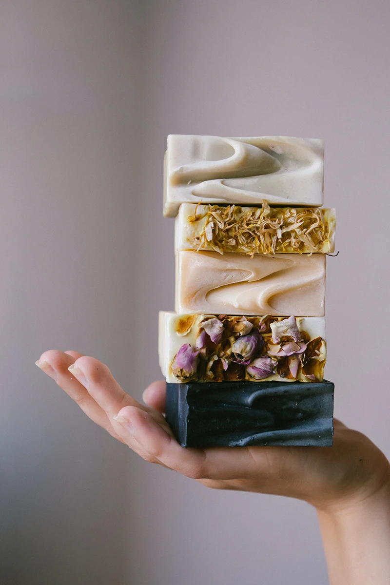 a close-up of woman's hand holding a bar of handmade soap