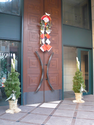 Two Kadomatsu outside an imposing door in Tokyo