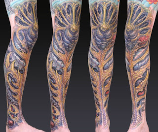 biomechanical tattoo on the leg: alien-like bones and tissues