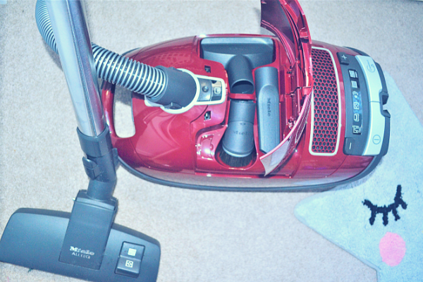 Miele Complete C3 Pure Red Bagged Cylinder Vacuum Cleaner showing the three additional tools stored under the hood