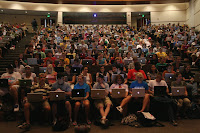 An auditorium full of students and every student has a laptop.