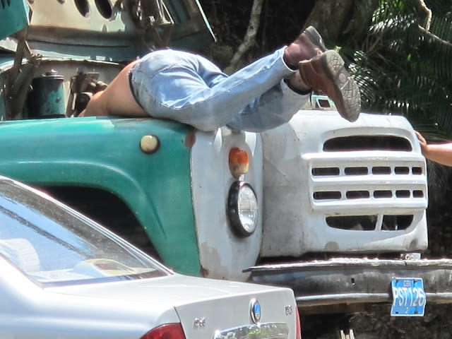 A frequent sight in Cuba-a mechanic working on one of the vintage vehicles.