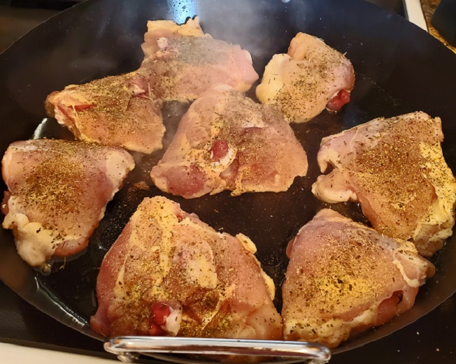 searing chicken thighs in a cast iron skillet