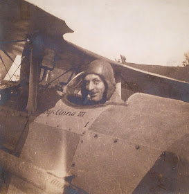 A photograph of a man's head peaking out of a small airplane.
