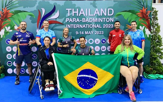 Equipe brasileira posa para foto em frente ao banner oficial do torneio