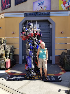 Rebecca posing with a Transformer before riding Transformers Ride