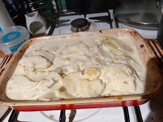 oven dish with sliced potato and cream in