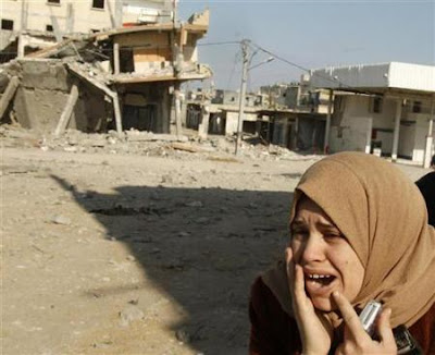 A Palestinian woman surveys the rubble