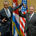 Raul Castro tries to lift up the arm of Barack Obama