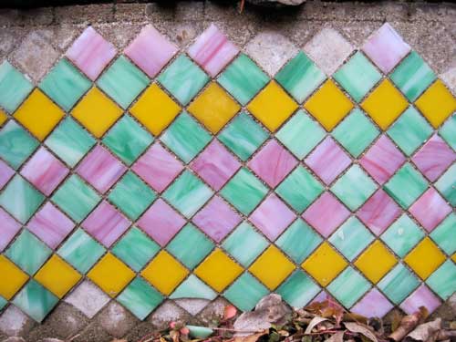 Orange pink and green square tiles in a harlequin pattern