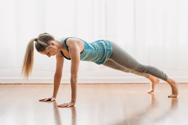 Woman doing plank pose in room