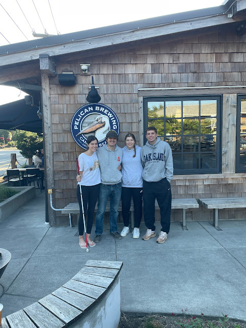 You, Andy, Elizabeth, Josh standing together in front of the Pelican Brewery sign.