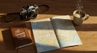 A wooden table with a travel map, steaming coffee, vintage camera, and a notebook labeled “Off-Season Travel”