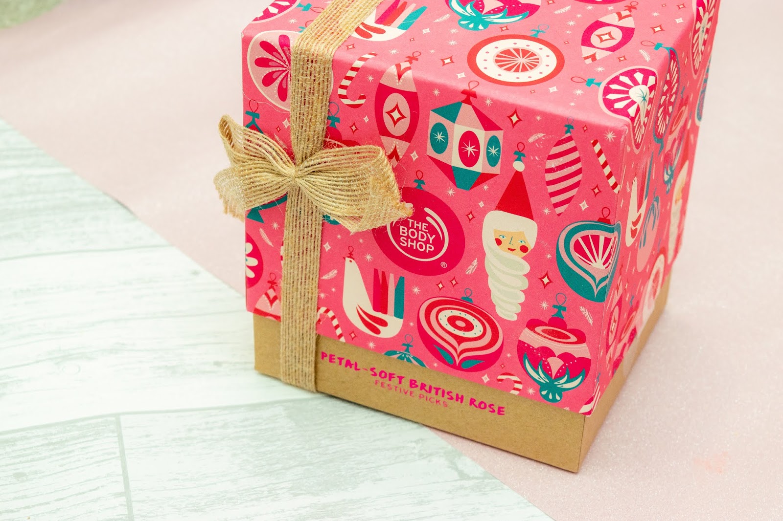 A pink box with Christmassy illustrations and a brown twine ribbon.