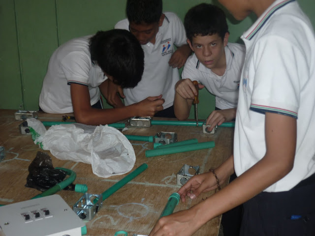 Niños trabajando en un tablero de instalaciones eléctricas  residenciales