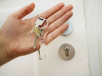 Image showing a buyer is holding keys to her newly owned real estate.