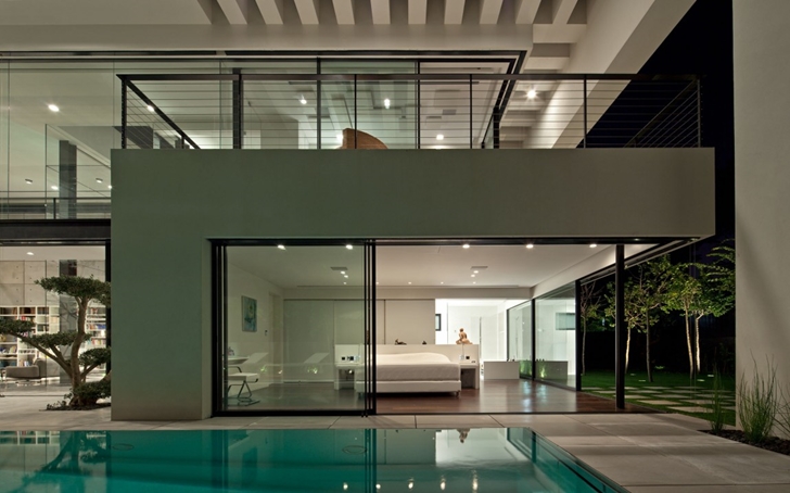 Glass wall of Modern Bauhaus Mansion In Israel at night 