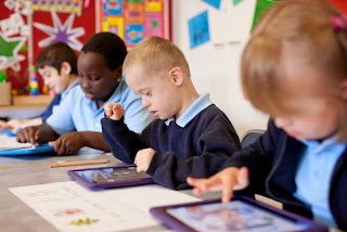 Students in a classroom using iPads