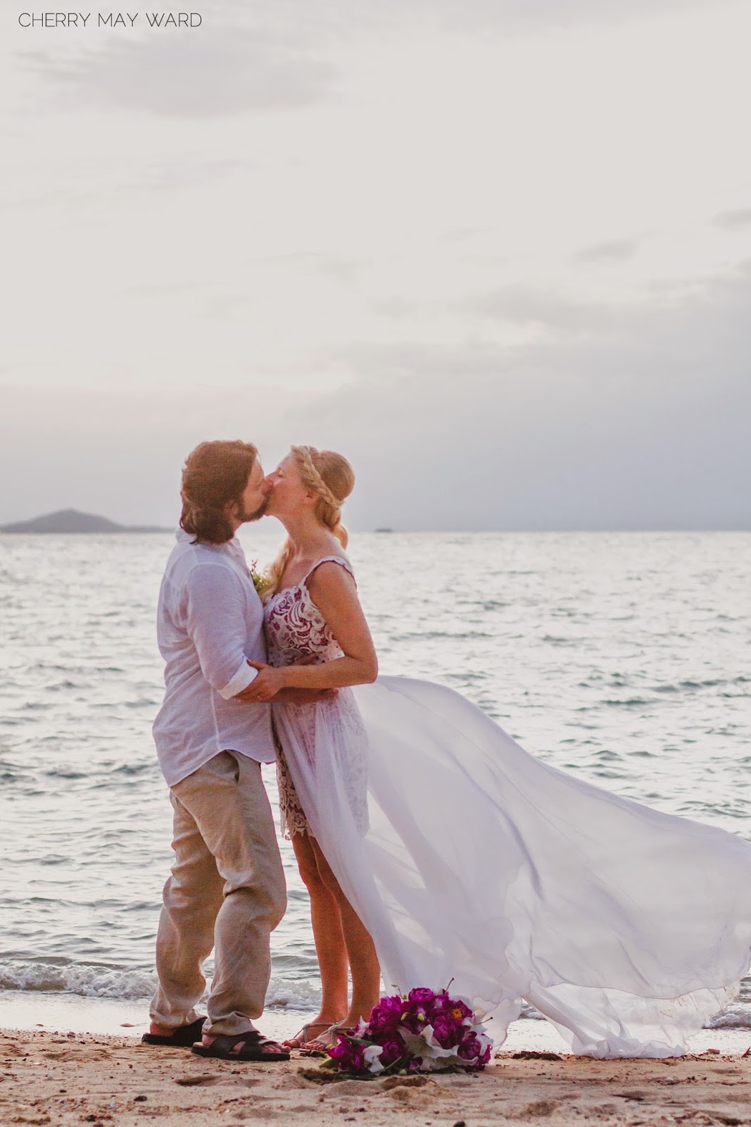 bride and groom kissing on the beach, destination wedding on Koh Samui Thailand, beautiful wedding photos, wedding dress blowing in the wind, 