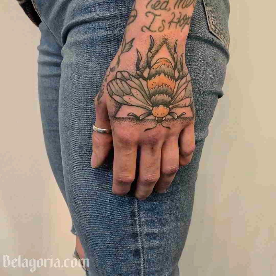 tatuaje de abeja en la mano de una mujer