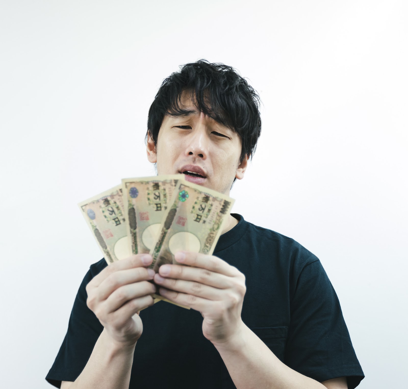 男性が三万円の紙幣を持って困った顔をしている