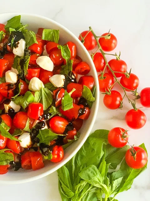 My Easy Chopped Cherry Caprese Salad is loaded with ripe cherry tomatoes, fresh basil, and fresh mozzarella pearls and drizzled with a balsamic glaze.