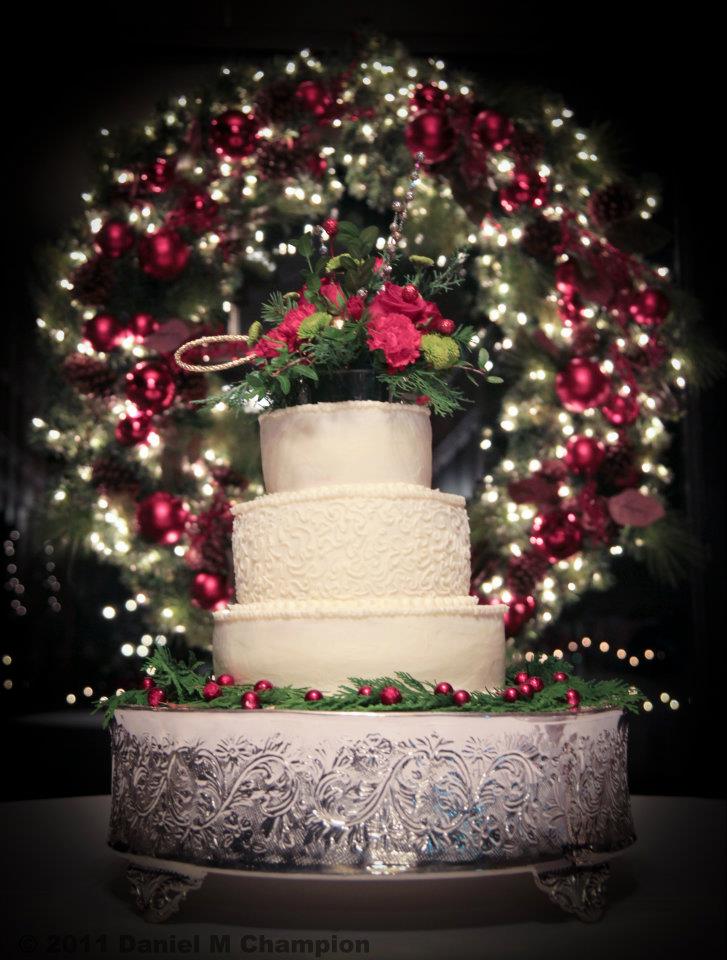 The bottom tier was surrounded by a vine of greenery accented by red 