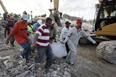 A group of volunteers carry a body in Puerto Principe, Haiti, 13 January 2010, after a 7.0 magnitude earthquake struck on 12 January.  EPA/Orlando Barrla