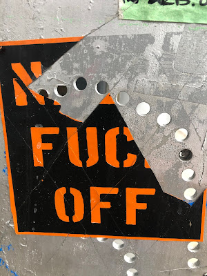 "Nazis Fuck Off" sticker on telephone booth ripped to say "N Fuc Off"