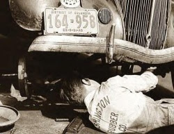 Vintage photo of mechanic working on car with DC plates