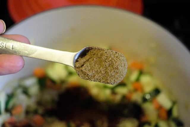 Cumin being added to the pot. 