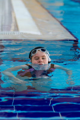 Photo of a child learning to swim in a pool