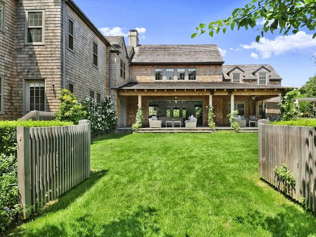 Grassy front yard of a house that's part of an East Hampton compound