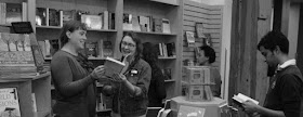 Black-and-white image of people browsing and reading in bookstore