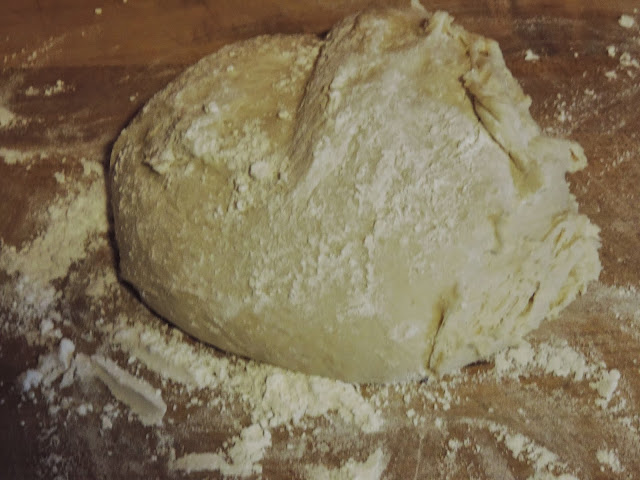 The dough for the homemade dinner rolls on a floured cutting board.