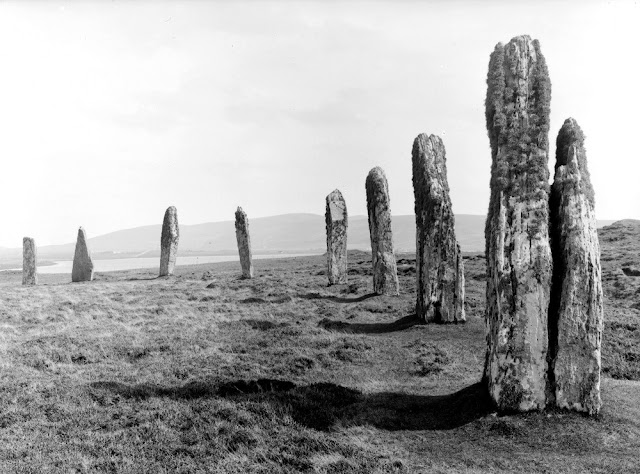 The Ring of Brodgar is a stone circle enclosed by a ditch, and occupies a commanding position on a narrow strip of land between the lochs of Stenness and Harray, in the heart of the Orkney mainland. This is a close-up view of several of the standing stones, some of which may have been cut out of the underlying bed-rock, when the ditch was constructed. The surrounding ditch was originally as much as 3 m. deep in some places.