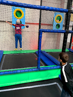 boys with arms outstretched jumping with a ball in his hand